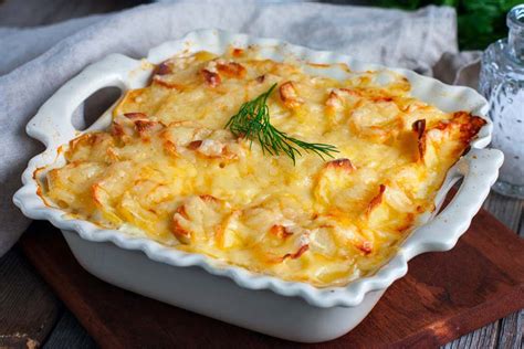 Plato de papas gratinadas con queso dorado y crujiente servido en una mesa rústica