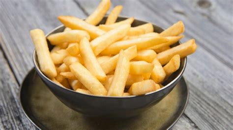 fotografía de papas en bastones remojándose en agua con vinagre