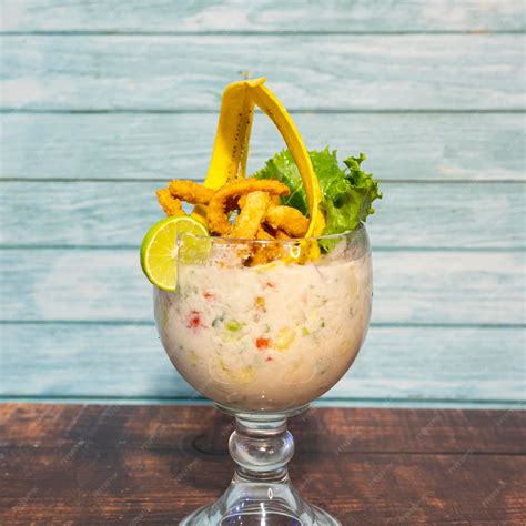 Foto de leche de tigre en un vaso pequeño, con un fondo desenfocado de ceviche.