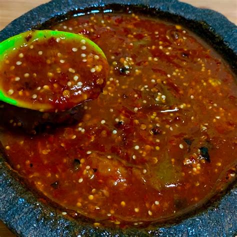 Jitomates, cebolla y ajo asándose en un comal o sartén