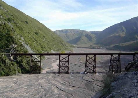 Paisaje panorámico de la Quebrada del Ají con sus colinas y el puente de acceso.