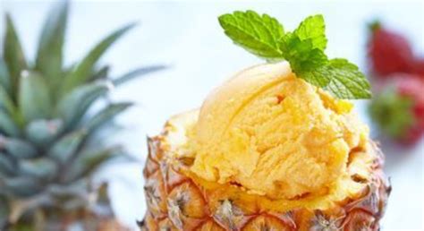 Tazón de helado de piña con trozos de fruta y decoración