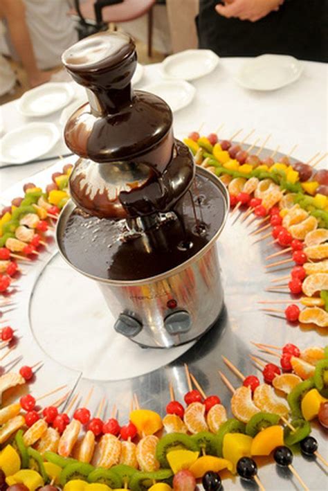 Foto de una fuente de chocolate decorando una mesa en una fiesta