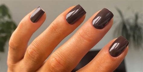 Mujer mostrando sus uñas con manicura color chocolate clásica