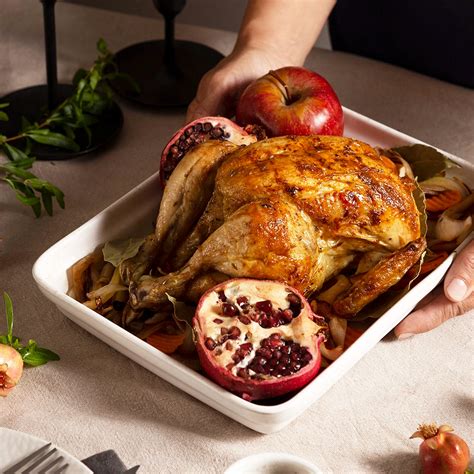 Pavo a la naranja entero, listo para servir, en una fuente grande con guarniciones cítricas