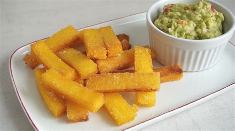 Bastones de polenta frita dorados en un plato
