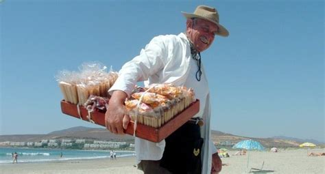 Vendedor ambulante en la playa ofreciendo barquillos y cuchuflís