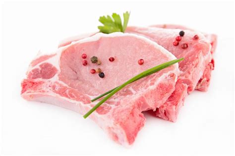 chuletas de cerdo frescas en una tabla de cortar, lista para marinar
