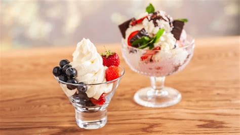 Fotografía profesional de una copa de postre con helado, frutas frescas y un toque de licor.