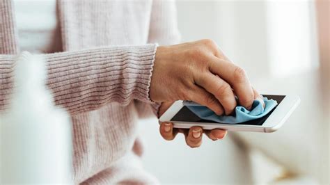Teléfono móvil limpiando la lente con un paño de microfibra