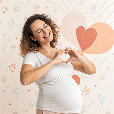 Mujer embarazada haciendo un corazón con las manos en su barriga