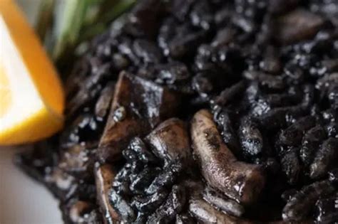 Arroz negro con berenjenas y carne, mostrando el color característico.
