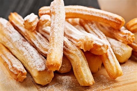 Detalle de la masa de churros siendo preparada con una pala de madera.