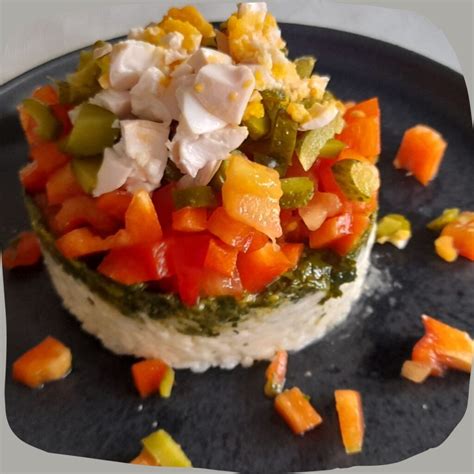 Pastel salado de espinacas y arroz, fresco, con vegetales coloridos y un aro de molde.