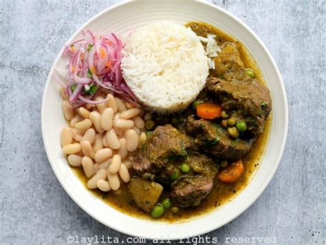 Foto de un plato de seco de carne de res acompañado de arroz y frijoles