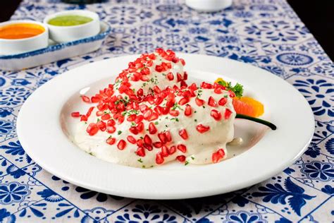Fotografía gastronómica de un chile en nogada servido en plato artesanal