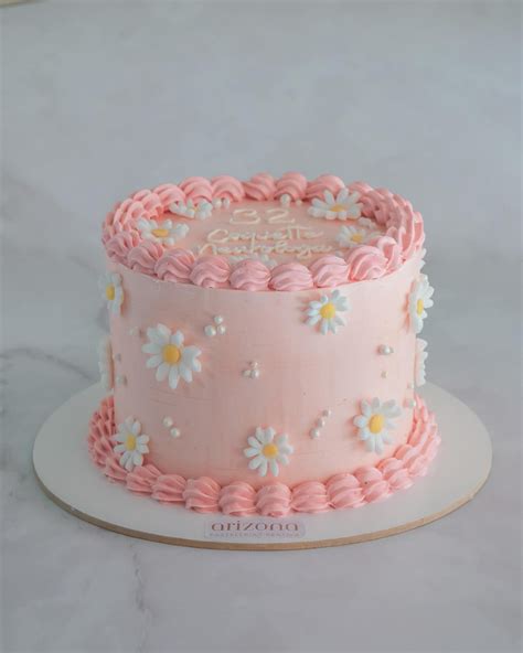 Un pastel rosa pastel elegantemente decorado con frutas y flores comestibles