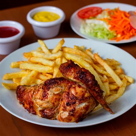 Imagen temática que muestra un plato de pollo a la brasa acompañado de un arroz chaufa y una Inka Kola bien fría.
