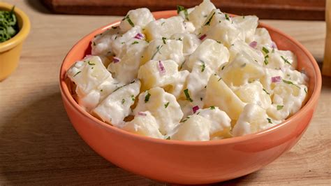 Imagen de ingredientes frescos para ensalada de papas: papas, zanahorias, cebollín, perejil