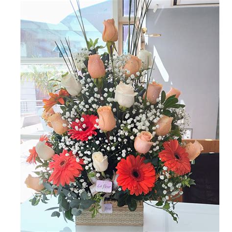 arreglo floral con predominio de tonos verdes, hojas y flores