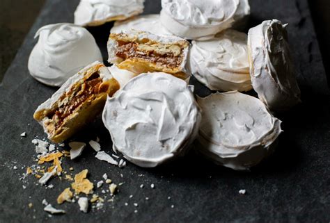 Fotografía de alfajores chilenitos recién horneados, con el merengue dorado y el manjar visible.