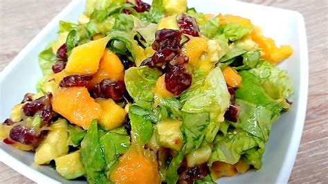 Foto de una ensalada fresca con lechuga, jícama, fresas y camarones, bañada en aderezo cremoso de mango.