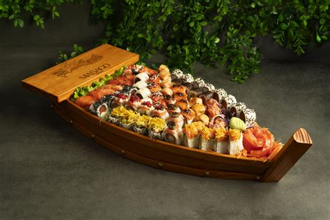 Detalle de un barco de sushi con una variedad de rolls coloridos y nigiris frescos
