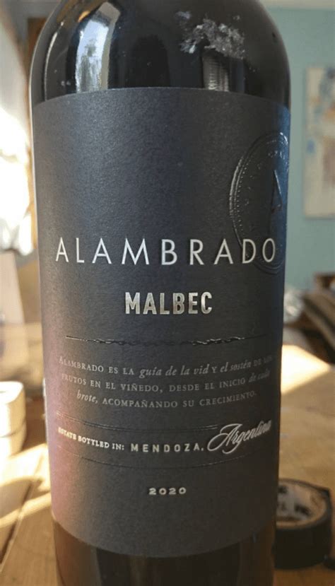 Botella de vino Malbec junto a empanadas de carne
