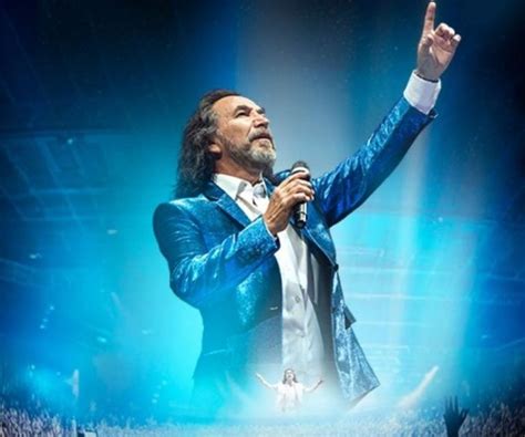 Fotografía artística de Marco Antonio Solís interpretando una balada en un escenario
