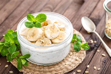 Imagen de un cuenco con yogur y trozos de plátano, decorado con galletas desmenuzadas