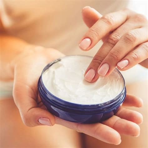 Crema de manos casera en un frasco de cristal con flores de lavanda y hojas de aloe vera