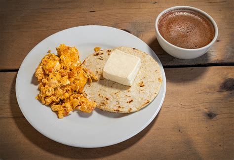 Variedad de desayunos colombianos con arepa, queso, chocolate caliente y huevos