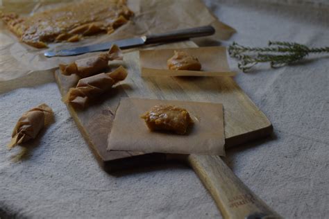 Fotografía detallada de una caluga de manjar artesanal sobre papel mantequilla tradicional.