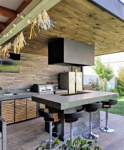 Parrilla integrada en un espacio exterior con mobiliario de diseño