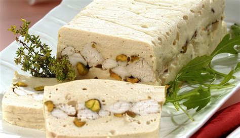 Plato de terrina de pollo con pistachos en lonchas servido con pan tostado y mermelada.