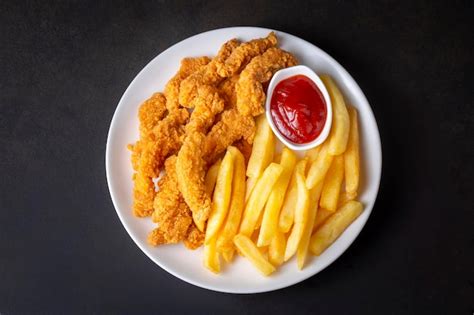 Plato de pollo crujiente servido con papas fritas doradas y salsas caseras