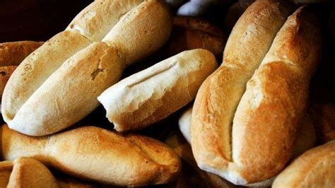 Mesa con diferentes tipos de pan chileno: marraqueta, pan amasado, hallulla