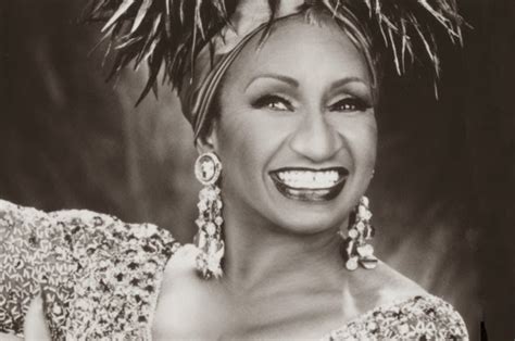 Retrato de Celia Cruz, sonriendo con su característico vestuario