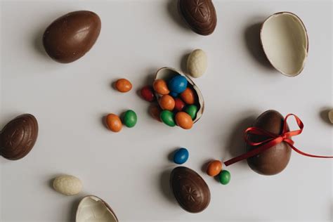 Fotografía detallada de surtido de huevos de chocolate y conejos artesanales presentados en packaging de lujo.