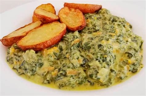 Plato servido de guiso de acelga y repollo con guarnición de papas horneadas