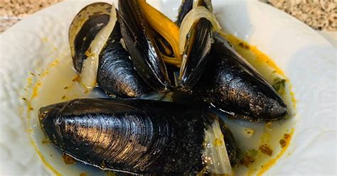 Fotografía de un plato de choritos frescos servidos con hierbas frescas y rodajas de limón