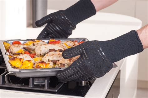 Fotografía de un cocinero utilizando guantes térmicos para manipular una olla caliente.