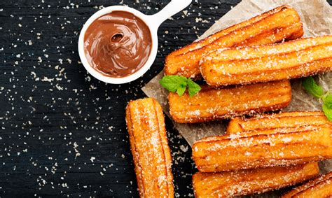 Imagen de una bandeja variada de postres españoles como churros y crema catalana