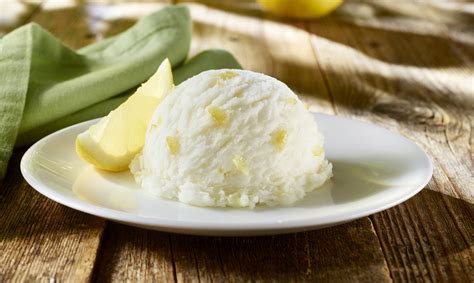 Fotografía profesional de una bola de helado de limón con textura cremosa y decorada con merengue suizo.