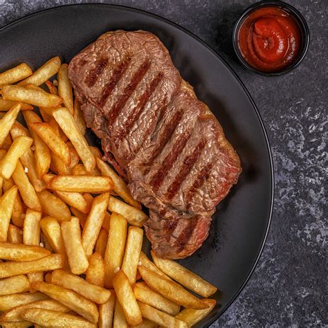 Imagen del filete de ternera extendido con el jamón y queso colocados para el relleno