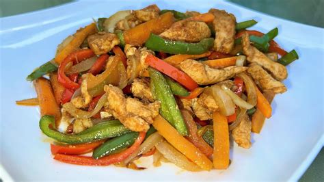 Fotografía de un plato equilibrado con pechuga de pollo en tiras, verduras salteadas y una ensalada fresca.