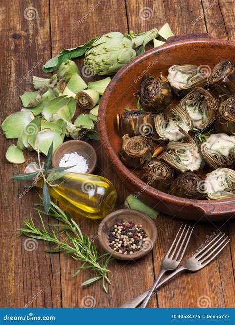 Imagen detallada de alcachofas frescas acompañadas de cítricos y hierbas aromáticas