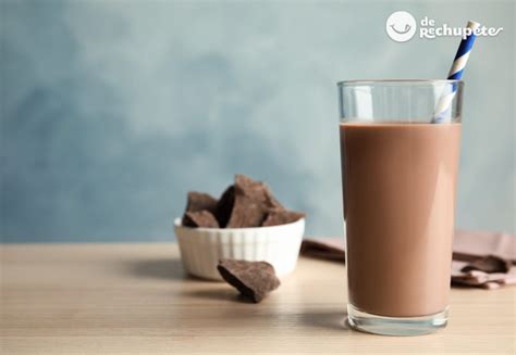 Imagen de un batido de chocolate amargo cremoso en un vaso de cristal con virutas de cacao por encima