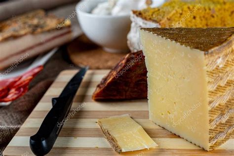 Primer plano de un trozo de queso parmesano con un rallador