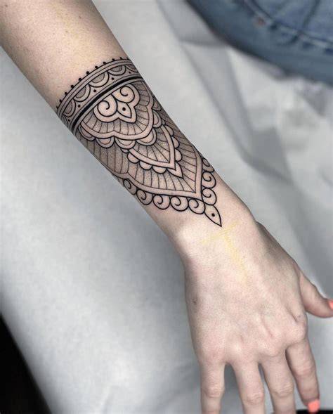 Mujer aplicando maquillaje para cubrir un tatuaje en el brazo.